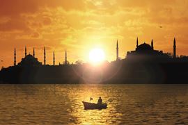 Europe Holidays - Turkey Holidays, Istambul - City silhouette with sun flare and the fishing boat